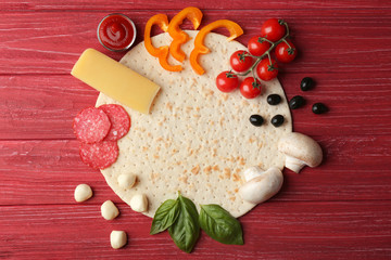 Raw pizza ingredients on wooden background, top view