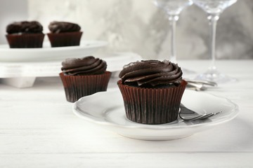 Tasty chocolate cupcake on plate