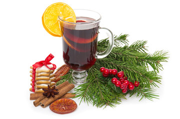 Mulled wine in glass with cinnamon stick, christmas tree and candy isolated on a white