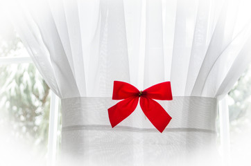 Red Bow on white curtain in Winter Scene with vignette.