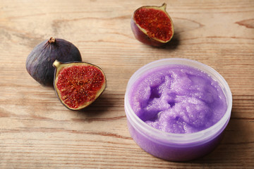 Body scrub and figs on wooden background