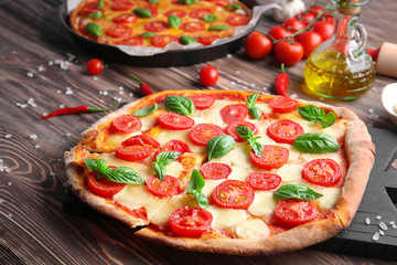 Delicious pizza on kitchen table