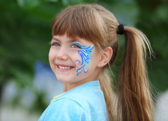 Naklejka premium Little girl with aqua makeup on blurred background