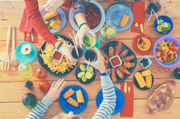 Top view group of people having dinner together while sitting at wooden table