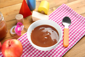 Bowl with healthy baby food on table. Child feeding concept