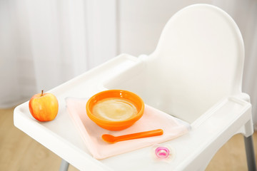 Highchair with healthy baby food at home. Child feeding concept