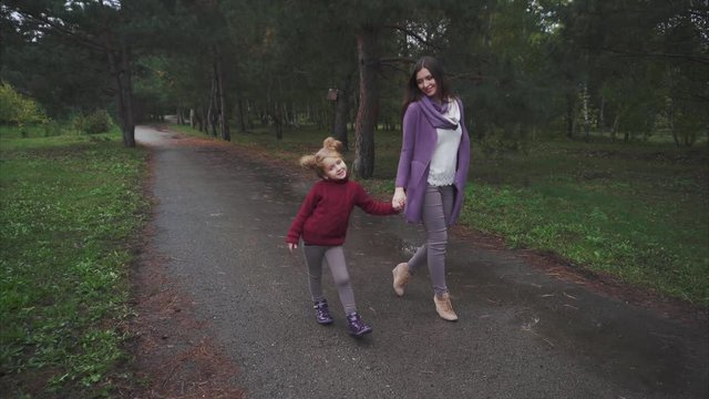 Mum and daughter walking in the autumn park 4K