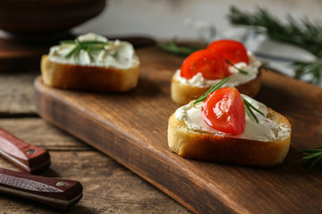 Delicious bruschetta with tomatoes on wooden board, closeup