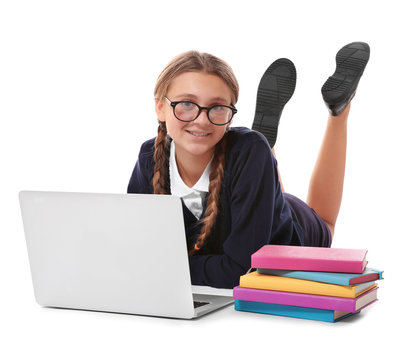 Teenage girl with pile of books and laptop lying on white background