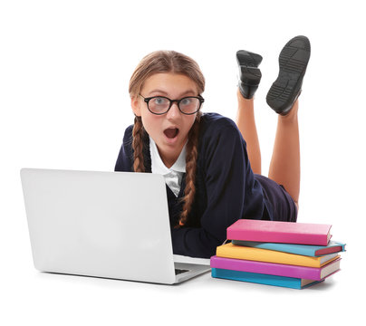 Teenage girl with pile of books and laptop lying on white background
