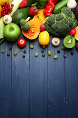 Set of fresh vegetables, fruits and berries on wooden background