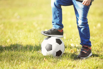 Little boy with ball on soccer pitch, close up view