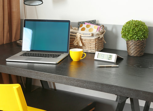 Workplace with laptop on desk in modern room