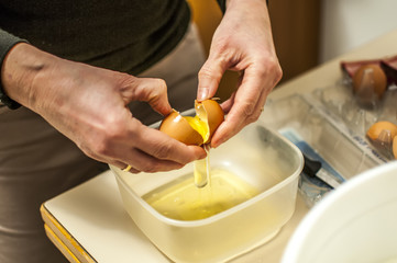 rompere le uova per preparare un dolce con impasto fatto in casa