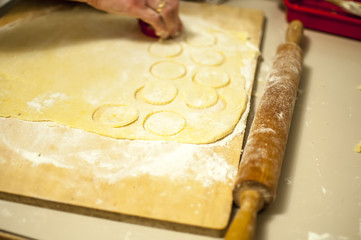 preparare i biscotti di natale con farina uova zucchero e marmellata con il mattarello