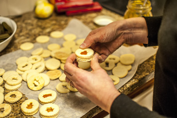 preparare i biscotti di natale a forma di cuore con farina uova zucchero e marmellata con il mattarello