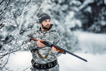 Male hunter in camouflage looking for his target or prey .Winter