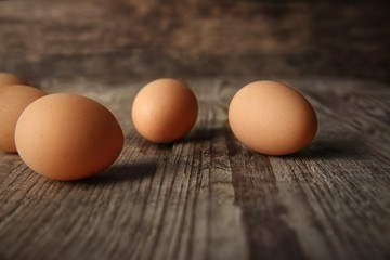 Raw eggs on wooden board, closeup