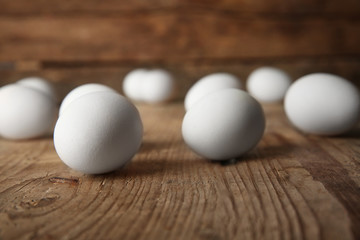 Raw eggs on wooden board, closeup