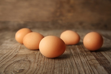 Raw eggs on wooden board, closeup