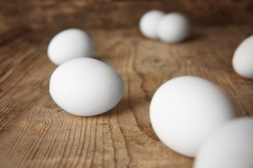 Raw eggs on wooden board, closeup