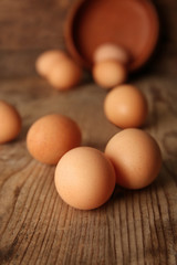 Raw eggs on wooden board, closeup
