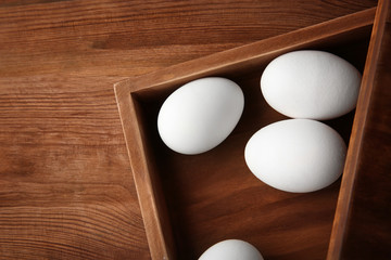 Raw eggs in wooden box