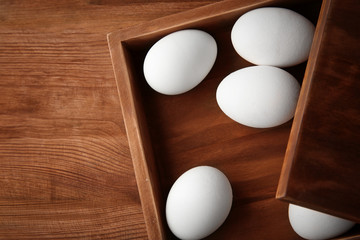 Raw eggs in wooden box