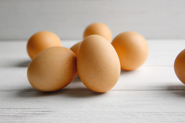 Raw eggs on wooden board, closeup