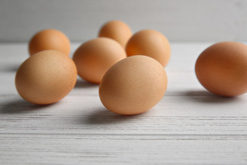Raw eggs on wooden board, closeup