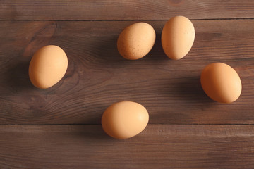 Raw eggs on wooden background