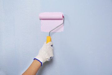 Hand of worker painting wall in room