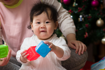 Asian baby girl playing toy with Mom