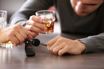 Woman taking car key from drunk man in bar, closeup. Don't drink and drive concept
