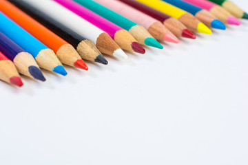 Naklejka premium Line of Colored Pencil Crayons Close Up Isolated on White
