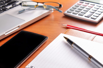 Office workplace with laptop and smart phone on wood table