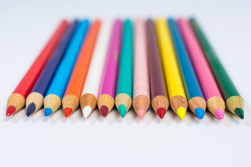 Line of Colored Pencil Crayons Isolated on White Front View