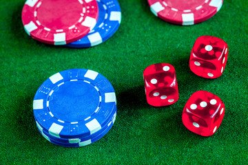 poker chips and dice on green background top view