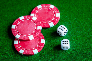 poker chips and dice on green background top view