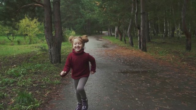 Little pretty girl running in the autumn park. Concept of happy childhood. HD.