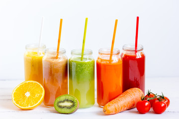 Fresh detox juices in glass bottles on white background