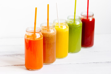 Fresh detox juices glass in row bottles on white background