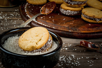 Cooking alfajores - a traditional dessert from Latin America or Mexico. Shortbread cookies with dulce de leche and coconut.