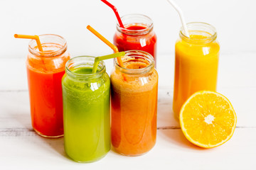Fresh detox juices in glass bottles on white background