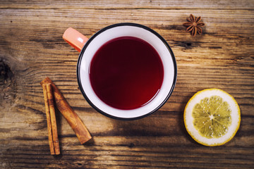 Simple tea mug, cinnamon, lemon and anise on a rustic wooden tab