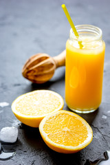 Naklejka na ściany i meble freshly squeezed orange juice on dark background
