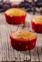 Pumpkin muffins in red paper baking molds on a wooden table