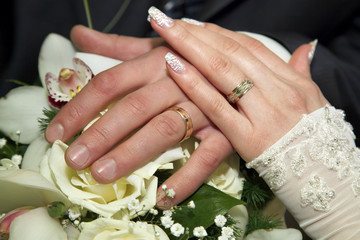 Obraz na płótnie Canvas hands of the bride and groom on the background of a wedding bouquet