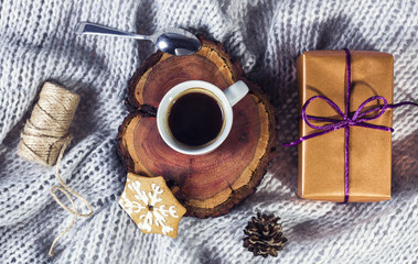 Hot coffe and a present on a grey blanket