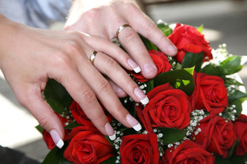 Obraz na płótnie Canvas hands of the bride and groom on the background of a wedding bouquet 